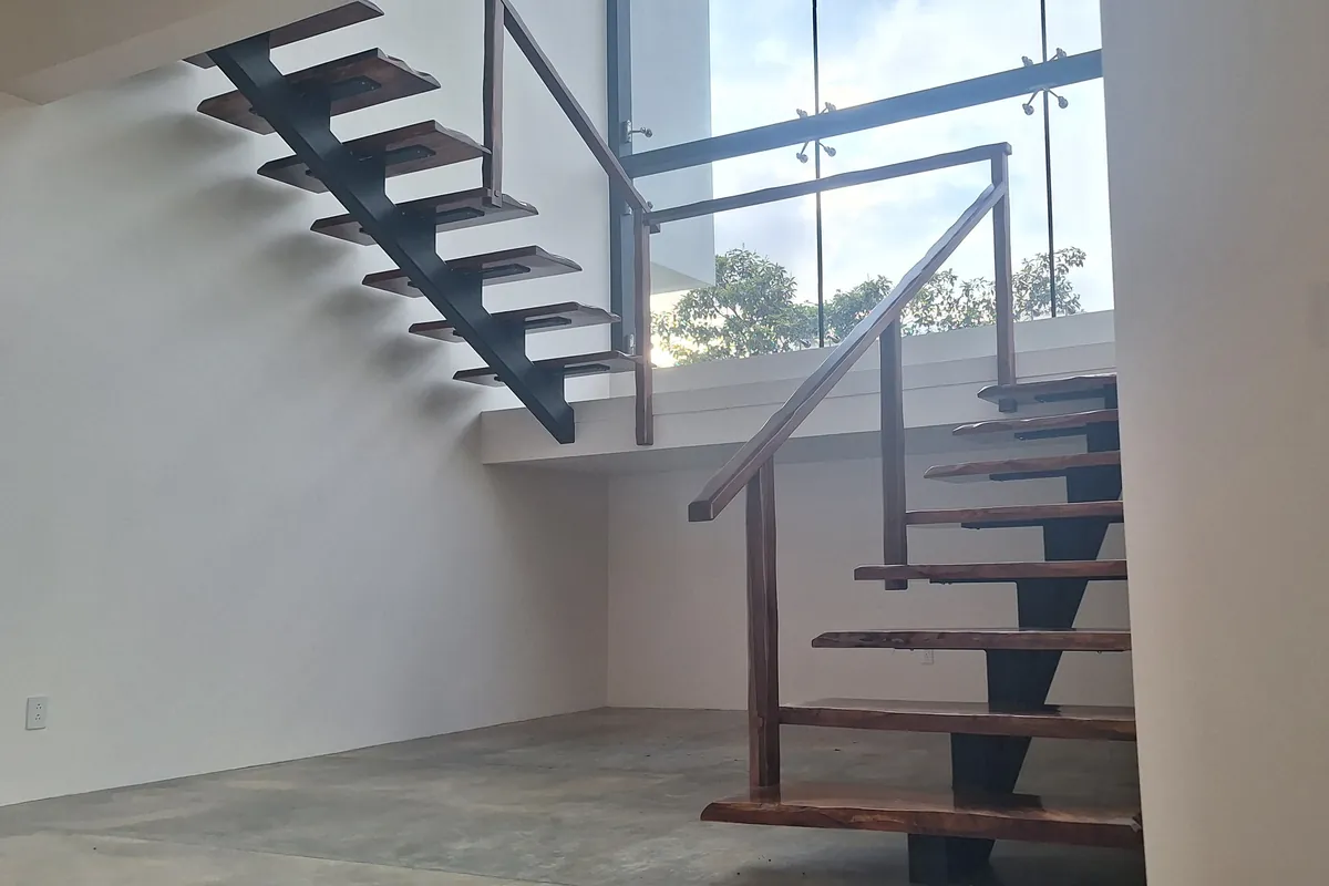 Escalera flotante con estructura de acero y peldaños de madera