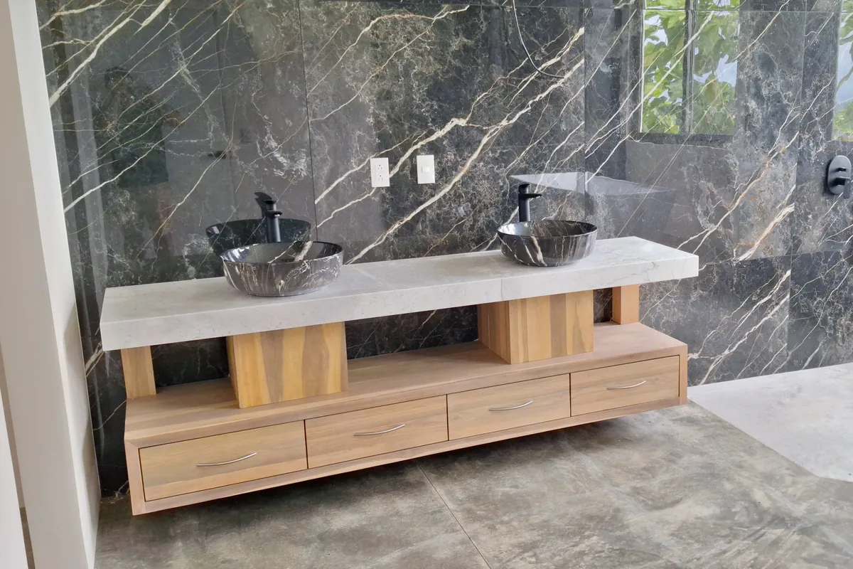 Mueble de baño en teca con doble lavamanos sobre mármol