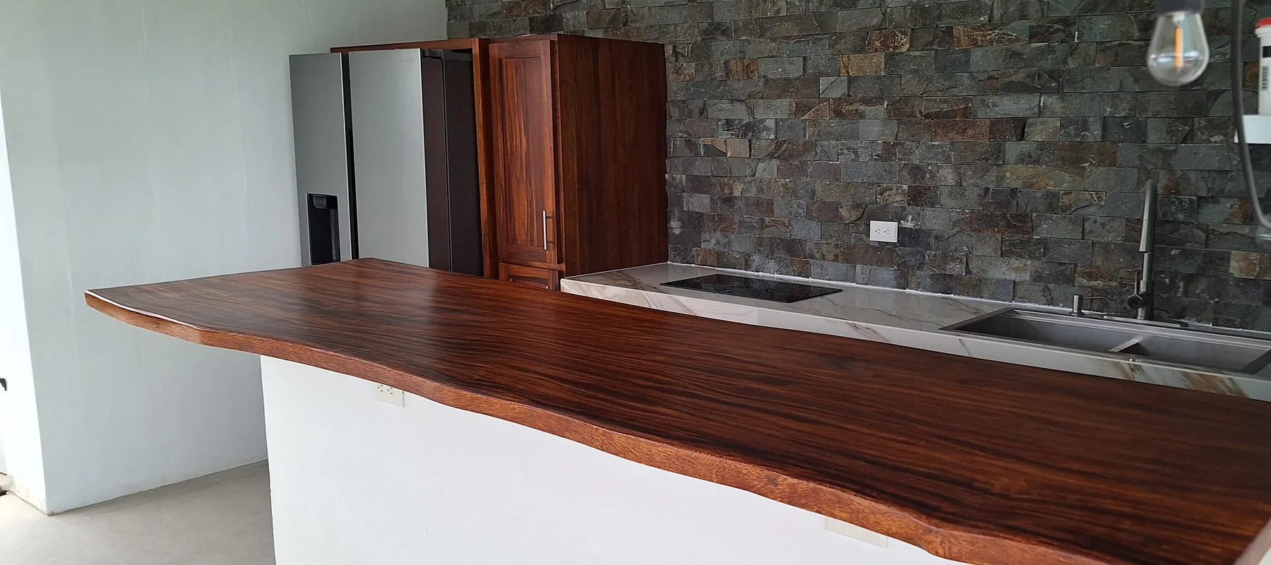 Barra de madera maciza con borde natural instalada en una cocina